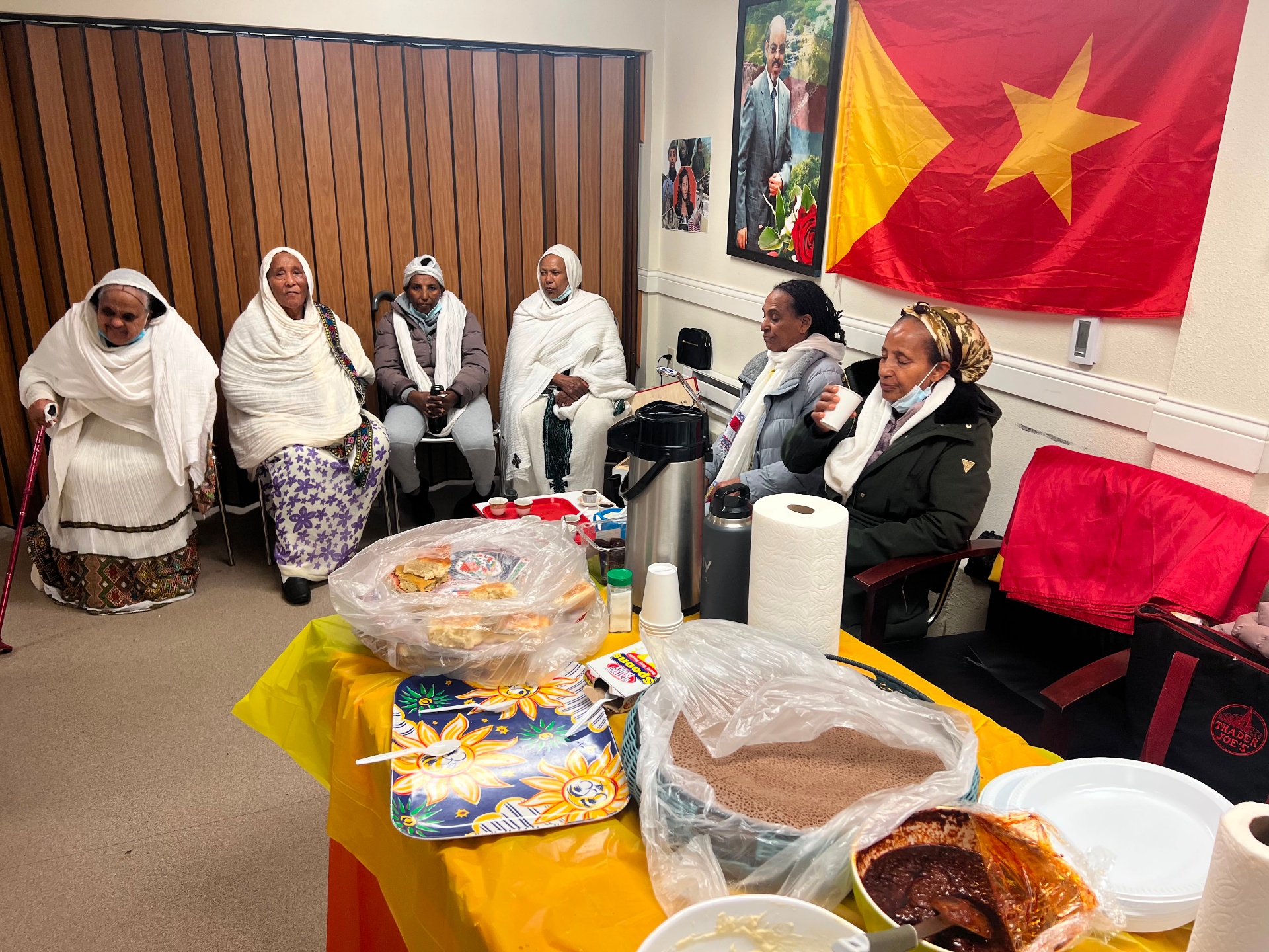 Tigrayan community members gathered with traditional food and the Tigray flag