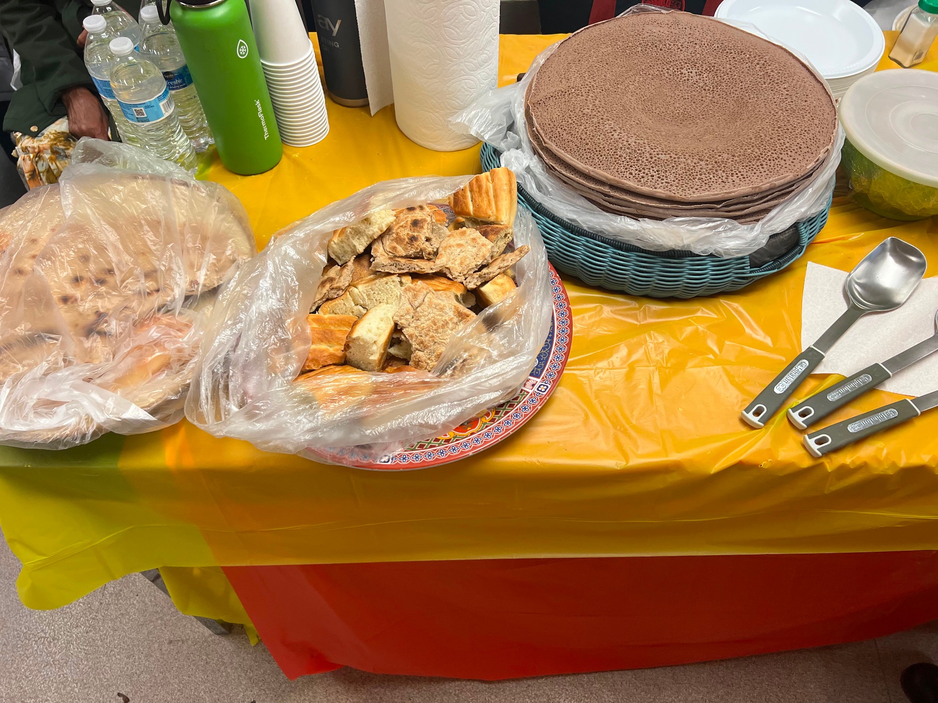 Traditional injera, himbasha, and bread served on a Tigrayan flag tablecloth