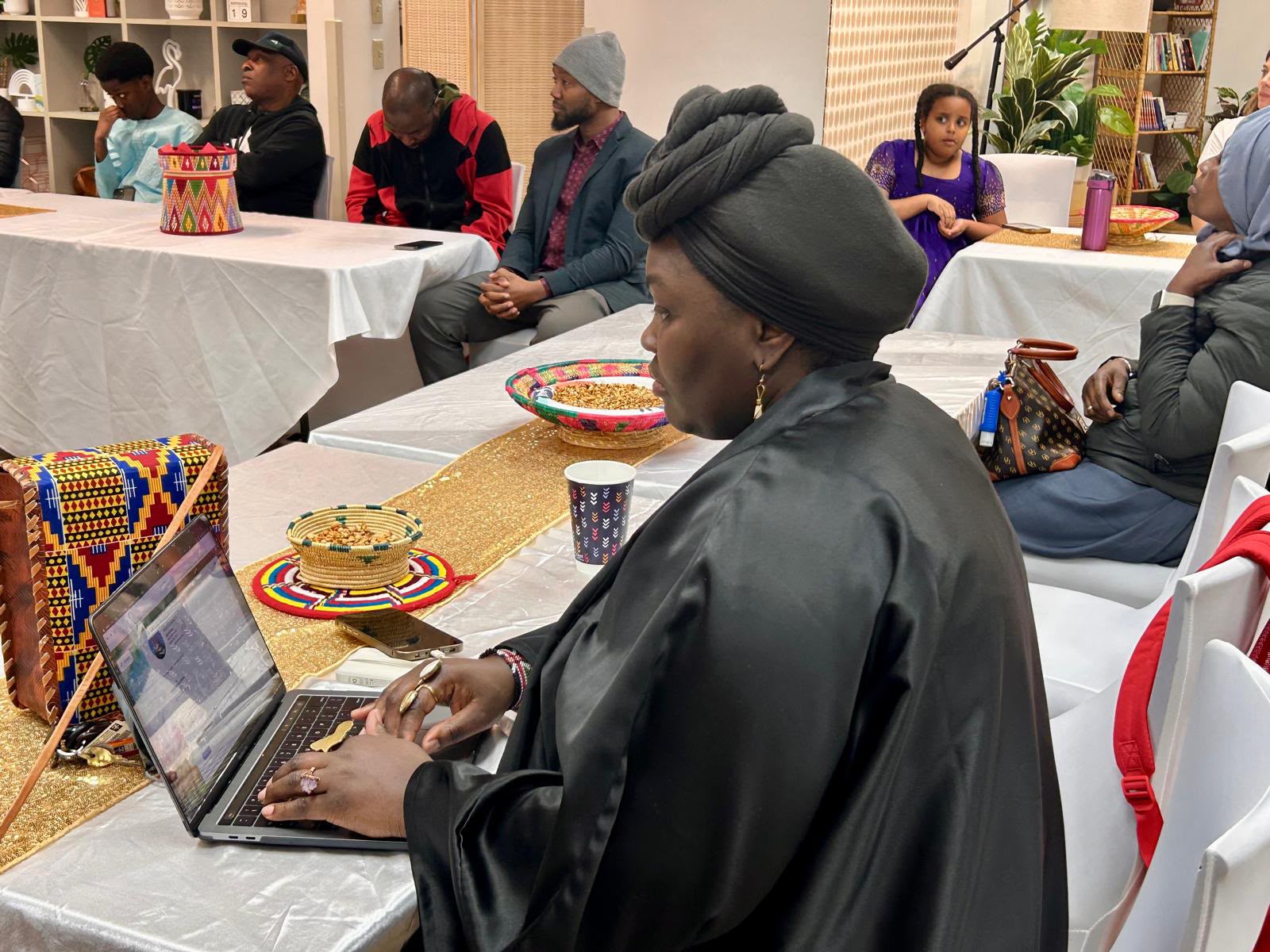 Community member at a cultural event with traditional Tigrayan decor and coffee ceremony baskets
